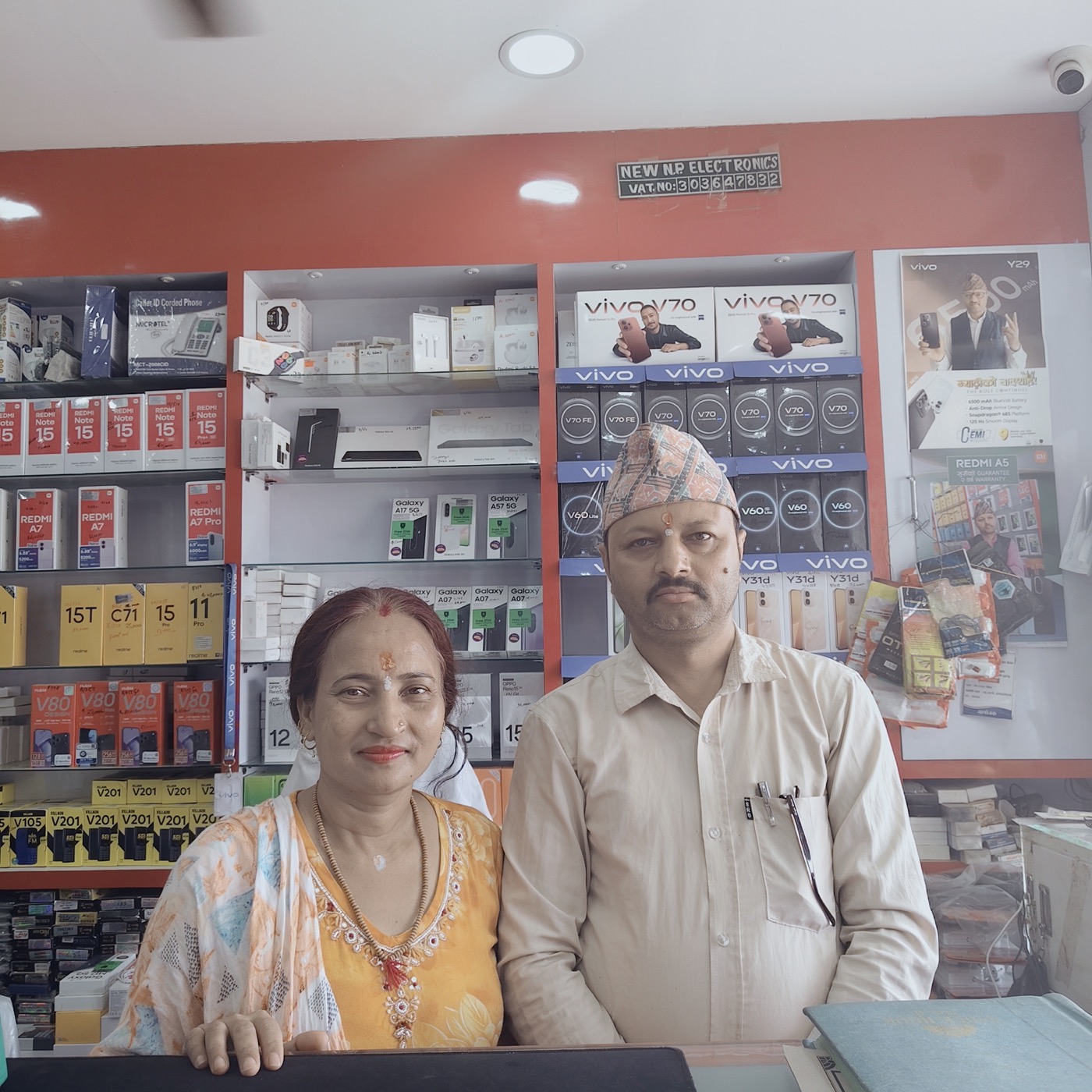 Netra Prasad Paudel and his wife at the New NP Electronics counter — the family running the shop